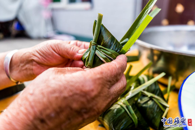 用葦葉包起來(lái)，再打個(gè)漂亮的結(jié)。中國(guó)雄安官網(wǎng)記者馬夢(mèng)迪 攝